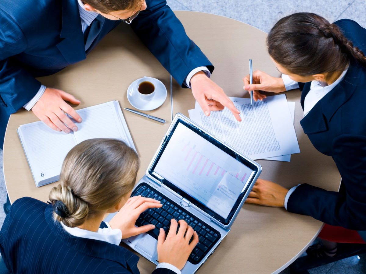 Image of three business people working at meeting